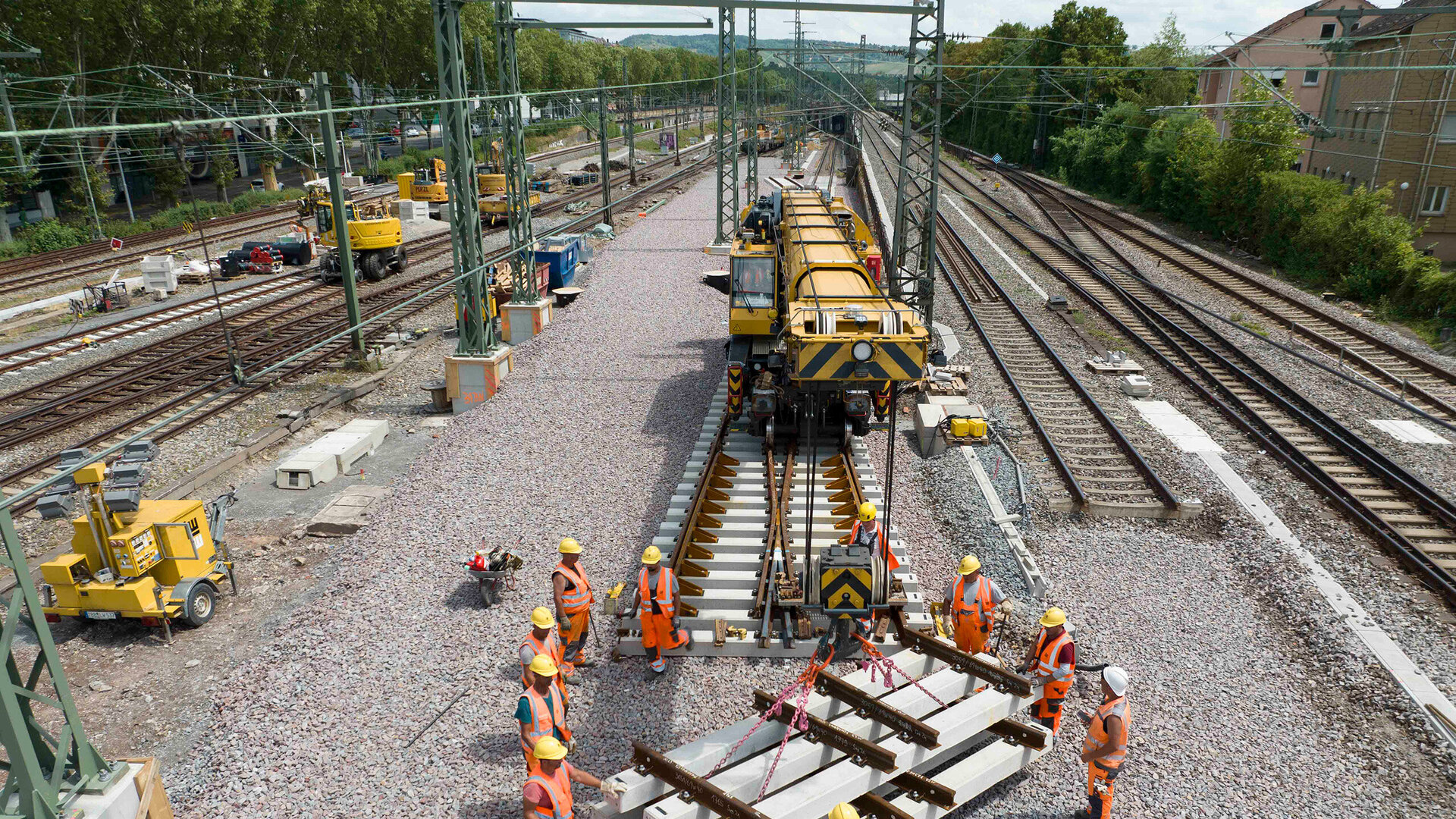 Arbeiter im Gleibett stehend, beim Einheben der Weichenteile mit Gleisbaukran