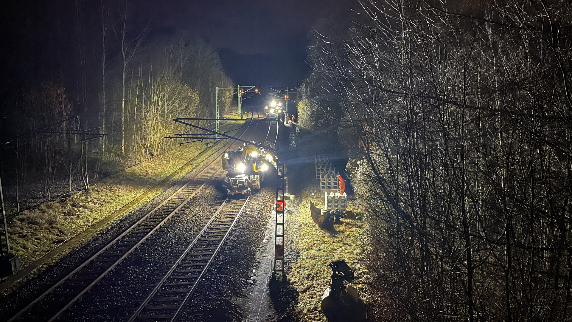 Nächtliche Aufnahem eines Schienenfahrzeugs beim Einsetzen von Betonkabelkanal.