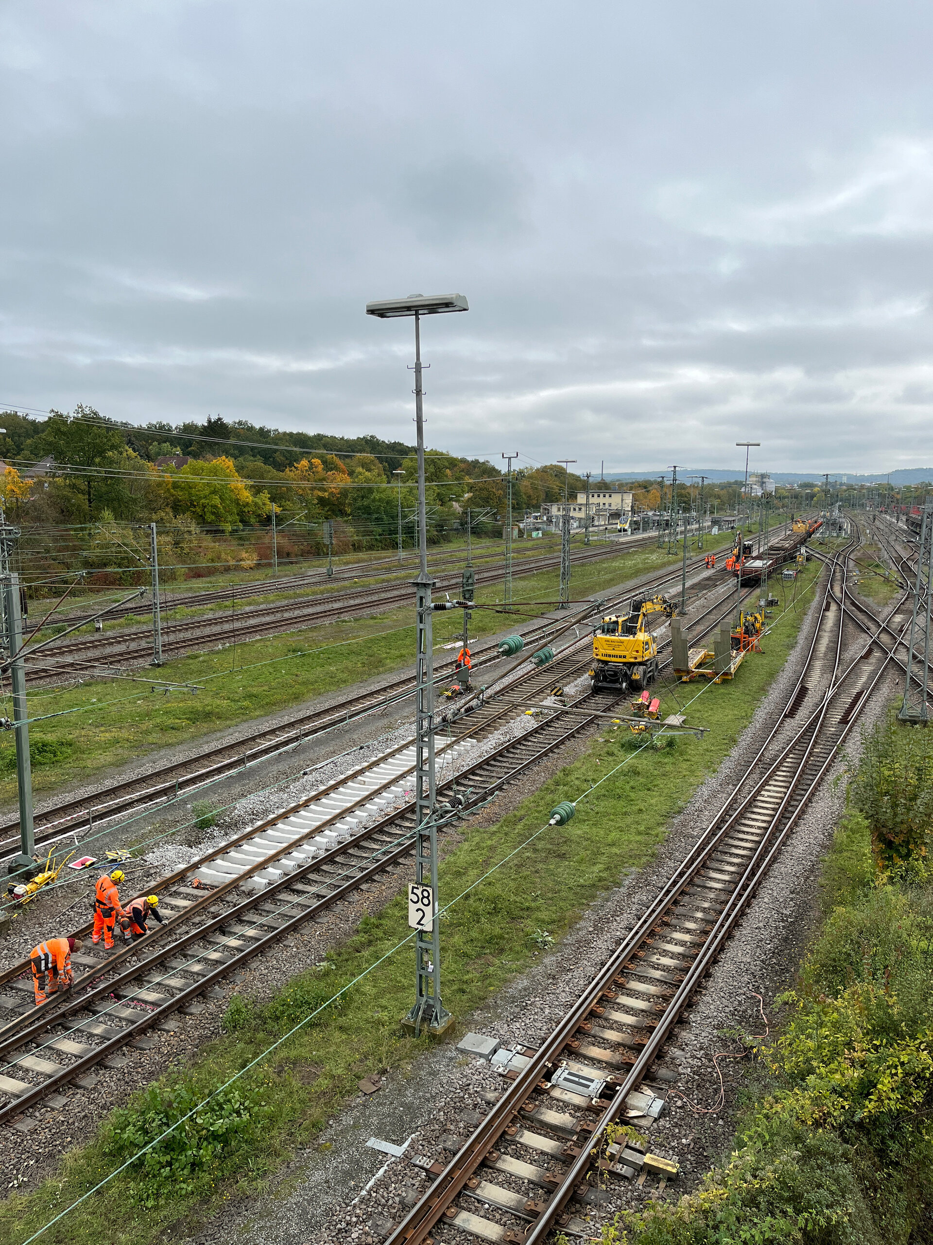 Arbeiter in orangefarbener Kleidung führen Gleisarbeiten auf dem Bahnhofsgelände von Bad Friedrichshall-Jagstfeld durch.