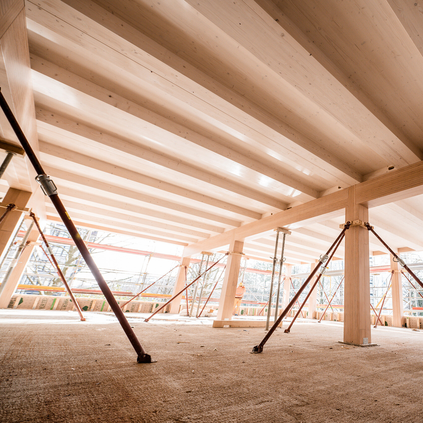 Ein Blick auf die Baustelle mit stabilen Holzträgern und Stützen, die die Struktur während der Bauarbeiten sichern.
