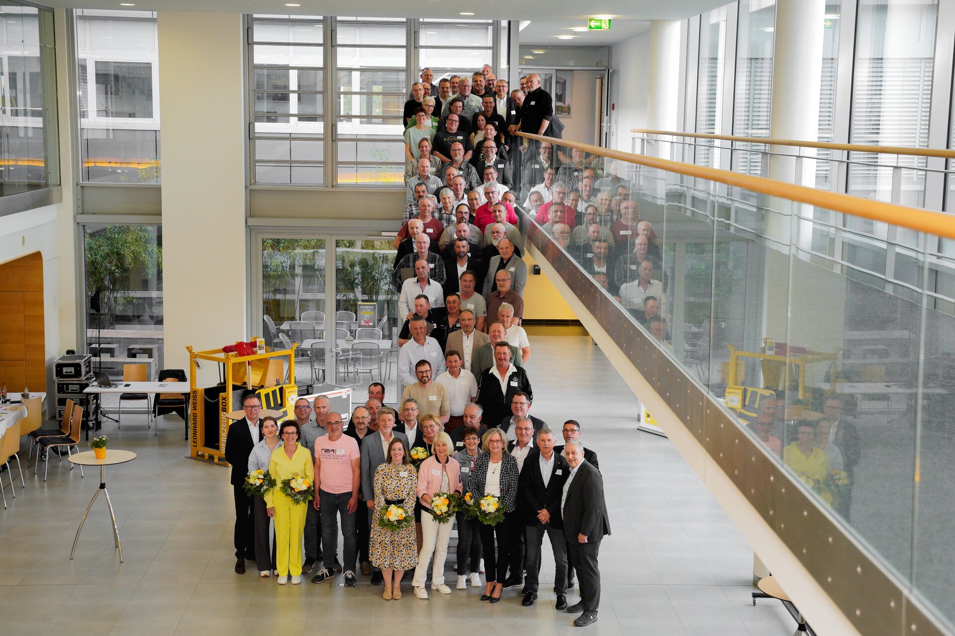 Viele glückliche Menschen stehen auf einer Treppe.